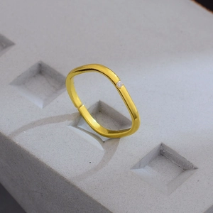 Minimalistischer goldener quadratischer Ring mit Kristall auf strukturiertem Steinsockel