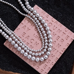 Collier de perles gris argenté à trois rangs avec haute brillance sur présentoir
