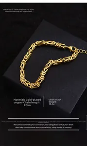 Détail d'un bracelet gourmette dorée de style byzantin sur un coffret noir texturé