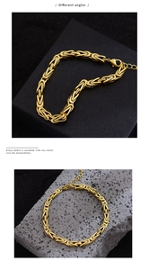 Détail du bracelet chaîne byzantine dorée avec fermoir mousqueton sur boîte noire