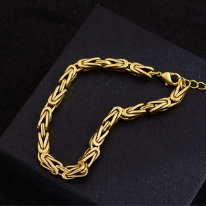 Bracelet byzantin doré avec texture de motif dragon sur boîte cadeau noire élégante