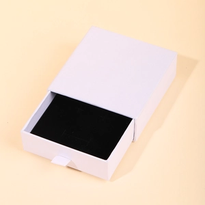 Boîte à bijoux blanche minimaliste avec doublure noire et poignée en ruban