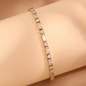 Détail d'un bracelet tennis doré avec alternance de zircons rectangulaires et ronds