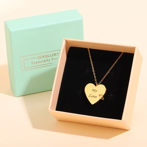 Close-up of gold heart necklace with My Love engraving in a pink velvet jewelry gift box