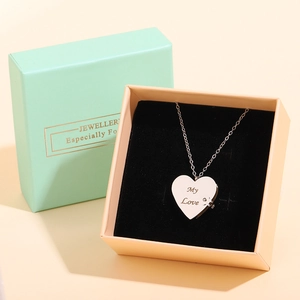 Detail of gold heart pendant with My Love engraving in premium pink jewelry gift box