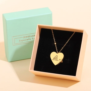 Detailed view of heart locket necklace with line art engraving in mint green gift box