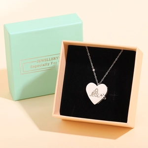 Macro shot of silver heart locket necklace in mint green and pink jewelry gift box