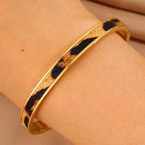 Dettaglio del bracciale dorato in acciaio inossidabile con inserto leopardato testurizzato
