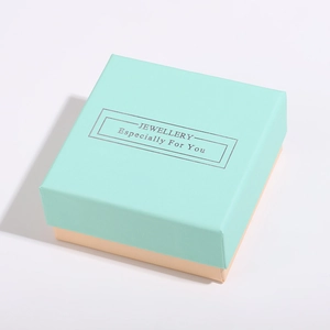 Vue de dessus d'un coffret cadeau bijoux bleu et beige avec lettrage argenté et ruban