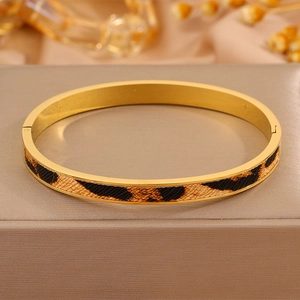 Dettaglio del bracciale rigido dorato in acciaio inossidabile con inserto leopardato