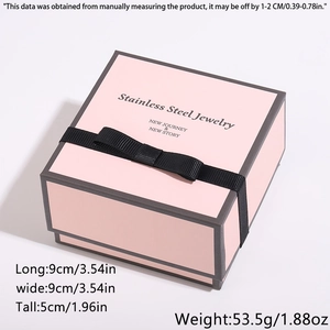 Boîte à bijoux rose avec nœud noir et dimensions de 9x9x5cm pour colliers et bagues