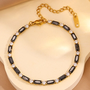 Détail macro du bracelet tennis doré avec zircons noirs et clairs alternés