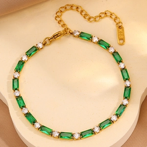 Détail d'un bracelet de tennis doré avec pierres vertes émeraude et zircons ronds