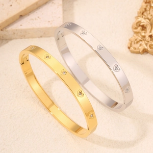 Bracciali in acciaio al titanio con cuori e zirconi incastonati, finitura oro e argento