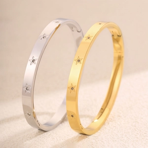 Dettaglio di bracciali a stella argento e oro con piccoli strass incastonati