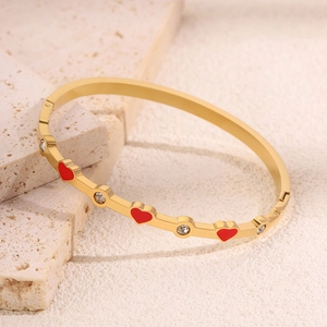 Dettaglio bracciale placcato oro con cuori in smalto rosso e pietre di zirconia cubica
