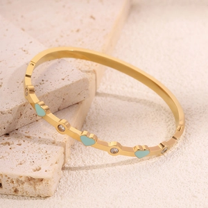 Dettaglio del bracciale in acciaio al titanio dorato con cuori in smalto blu e cristalli