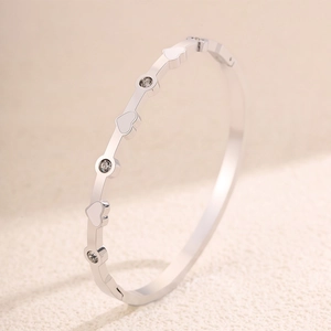 Dettaglio del bracciale in acciaio lucido con icone a cuore e cristalli incastonati