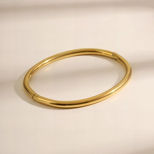 Gepolijste gouden titanium stalen ovale armband met een minimalistisch scharnier