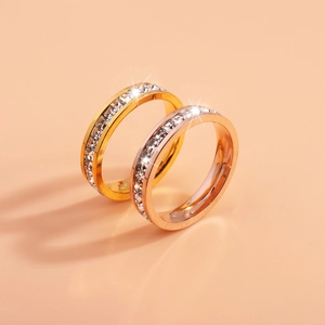 Gros plan de bagues éternité en or et or rose avec zircons carrés sertis sur fond beige