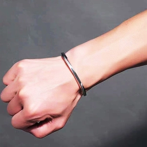 Detailed close-up of a silver Mobius titanium steel bangle on a wrist with polished finish