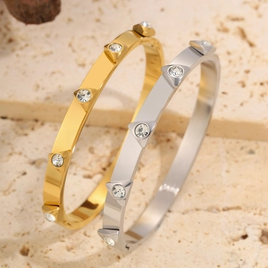 Detail of gold and silver geometric stainless steel bangles with triangle diamond studs
