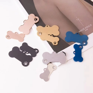 Polished bone-shaped stainless steel pet tags with paw cutouts in five metallic colors