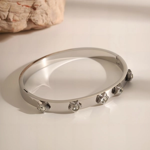 Close-up of silver-tone stainless steel star bangle featuring sparkling crystal centers