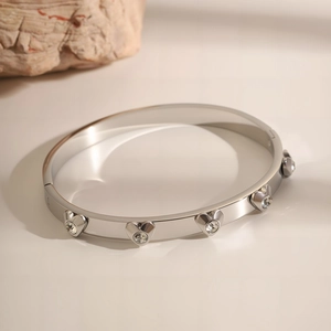 Detailed view of silver stainless steel heart bangle with sparkling crystal accents