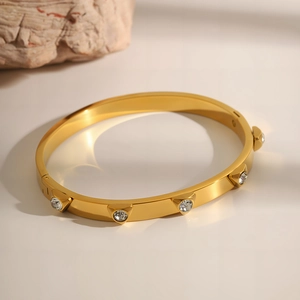 Detail of gold-plated stainless steel bracelet with triangle settings and round zircons