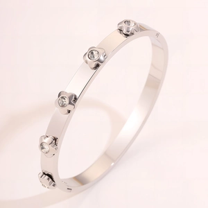Detailed view of silver stainless steel bangle with flower charms and zircon stones