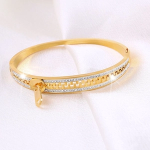 Close-up of a gold-plated zipper bracelet with sparkling white zircon stones on silk