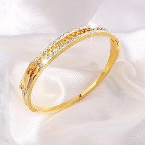 Close-up of golden stainless steel zipper bracelet with sparkling cubic zirconia inlay