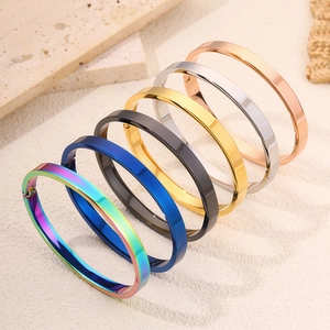 Minimalistische roestvrijstalen armbanden in zes gepolijste kleuren op natuurstenen achtergrond