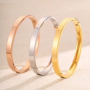 Detail van gepolijste roestvrijstalen armbanden in roségoud, zilver en goud kleuren