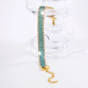 Lussuoso bracciale in acciaio al titanio dorato con quattro file di cristalli blu e chiari