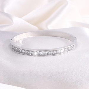 Dettaglio del bracciale in titanio argento con zirconi quadrati su seta bianca