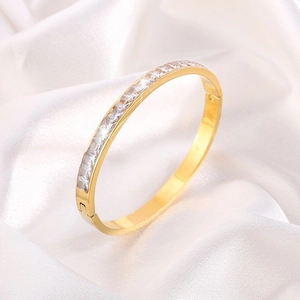 Dettaglio di un bracciale in titanio placcato oro 18K con file di pietre Moissanite