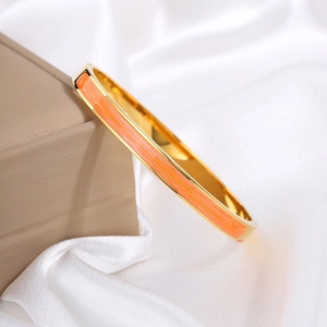 Detail van een elegante oranje geëmailleerde vergulde armband op een juwelendoosje
