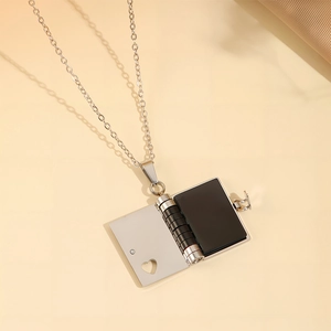 Collier en acier titane avec un pendentif livre ouvrable et un design de cœur