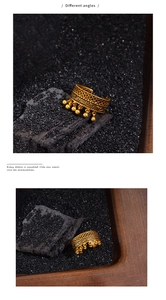 Detailed close-up showing the hollow lace pattern and gold bead charms of the vintage ring