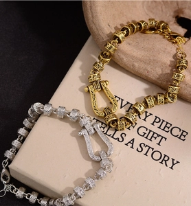 Detail eines Vintage Hufeisen Armbands mit verzierten floralen Ranken in Gold und Silber