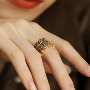 Vintage gold textured ring with delicate hollow lace patterns and small beaded tassels