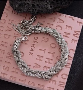 Gros plan sur un bracelet tressé argenté avec fermoir mousqueton réglable