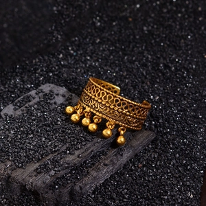 Vintage gold hollow lace open ring with seven dangling beads on a charcoal background