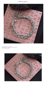 Gros plan d'un bracelet tressé vintage en argent avec pompon et fermoir homard