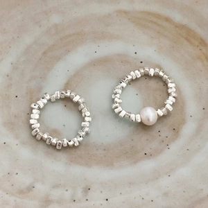 Minimalistischer Silberring mit Süßwasserperle auf Keramikhintergrund im Design