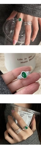 Dettaglio di anelli d'argento con pietra ovale verde e motivi a foglia vintage materici
