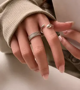 Detail of silver irregular geometric rings with striped texture and smooth liquid metal finish