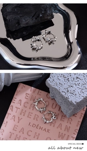 Macro shot of silver liquid lava texture earrings with a high-shine metallic mirror finish